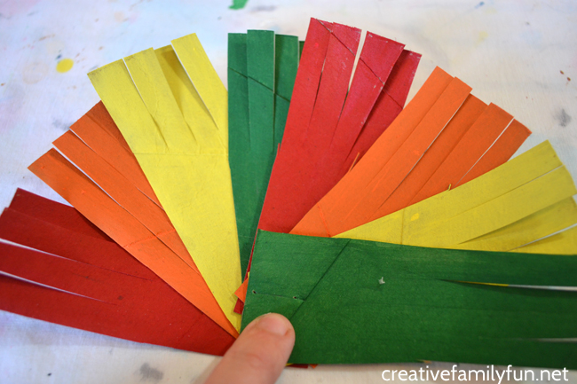 Cardboard pieces fanned out in a variety of Thanksgiving colors, red, orange, yellow, and green
